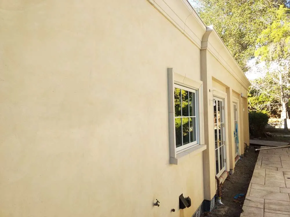 Exterior view of a residential building with smooth stucco finish and windows, located in Hillsborough.