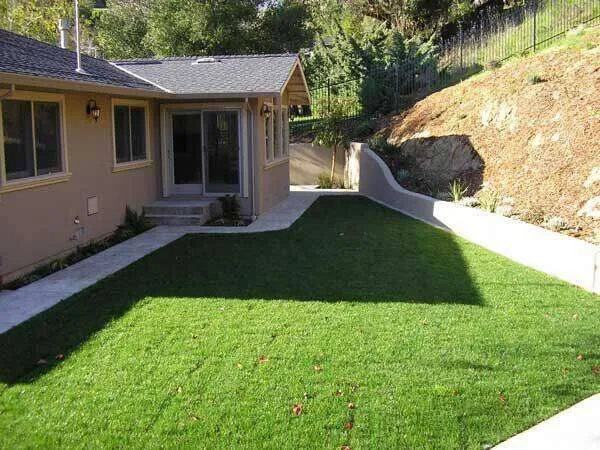 Stucco exterior of a single-family home with a lawn and concrete path in Greenbrae.