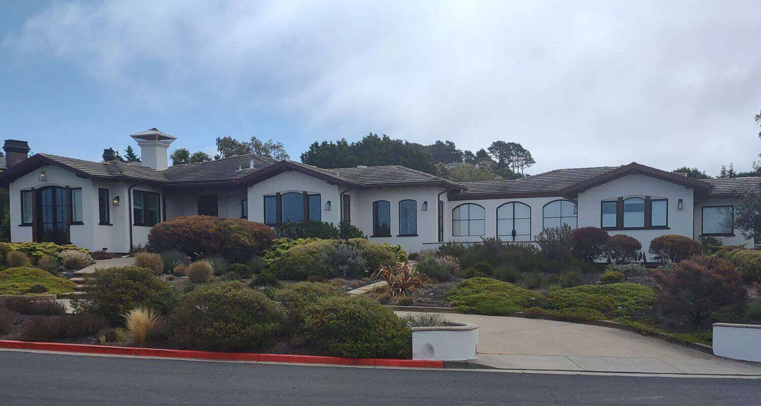 Large single-story house with white EIFS exterior and dark-framed windows in Tiburon.